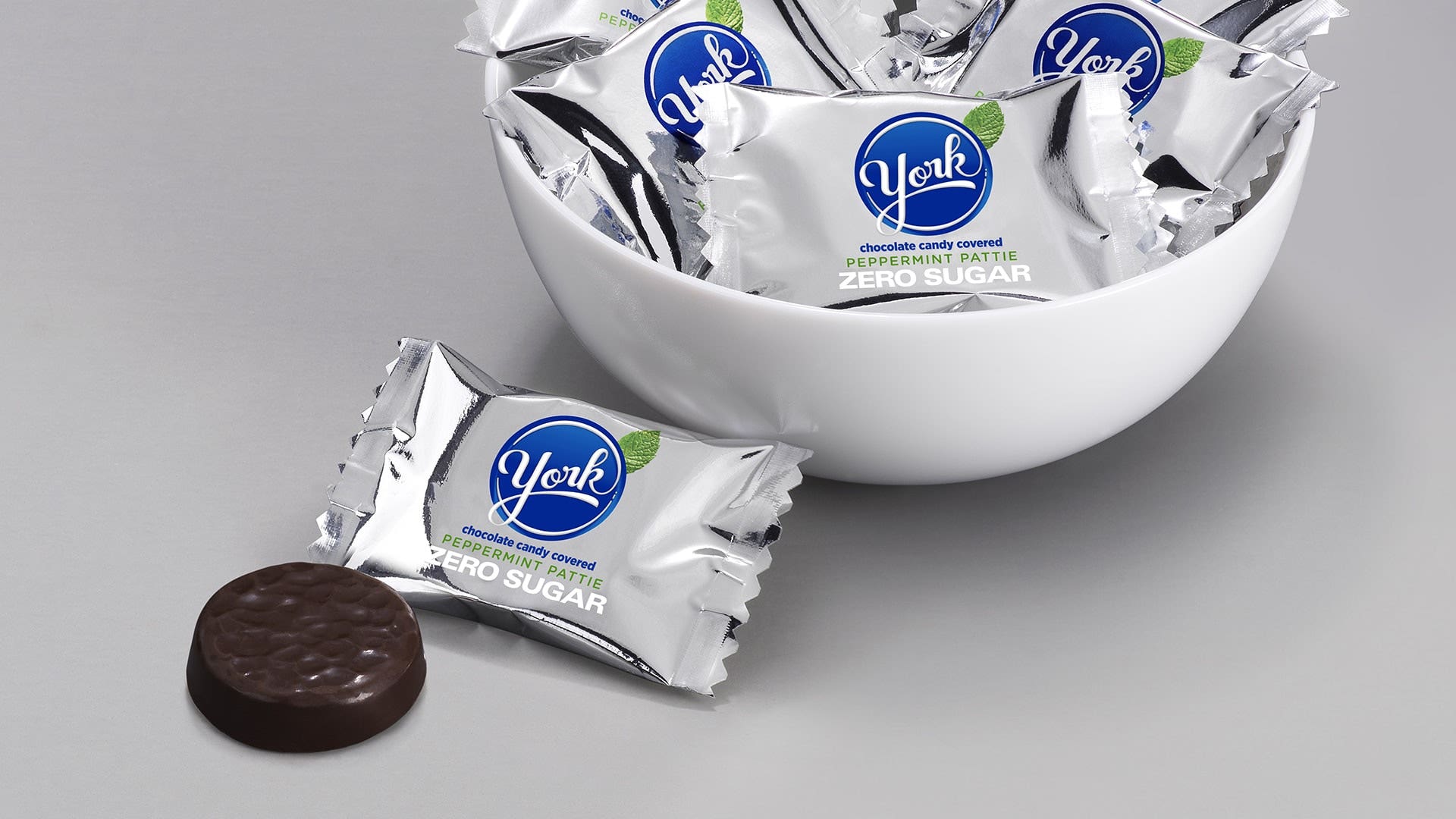 York Peppermint patties inside a white bowl on a grey table.